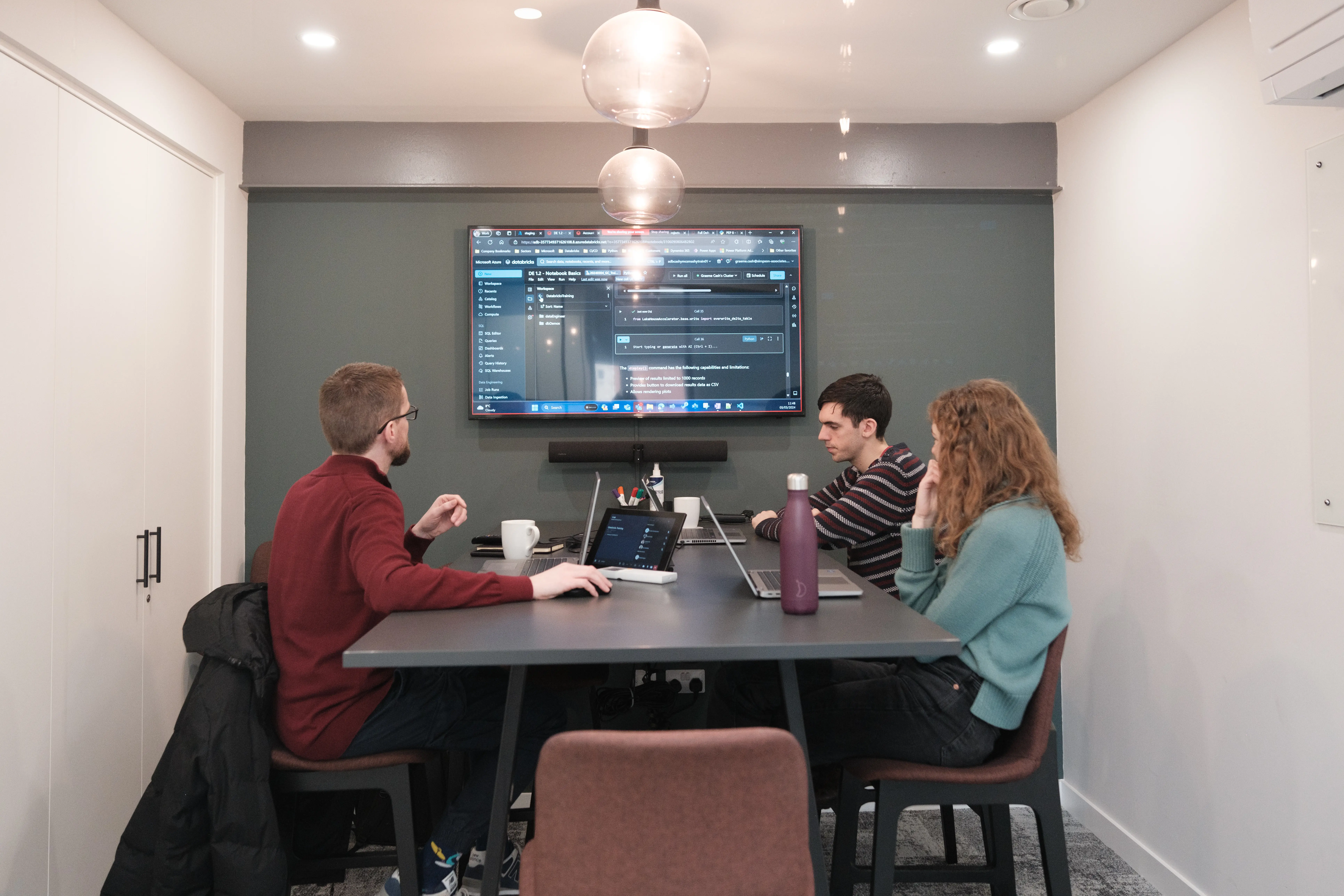 3 people sat in a meeting room doing training