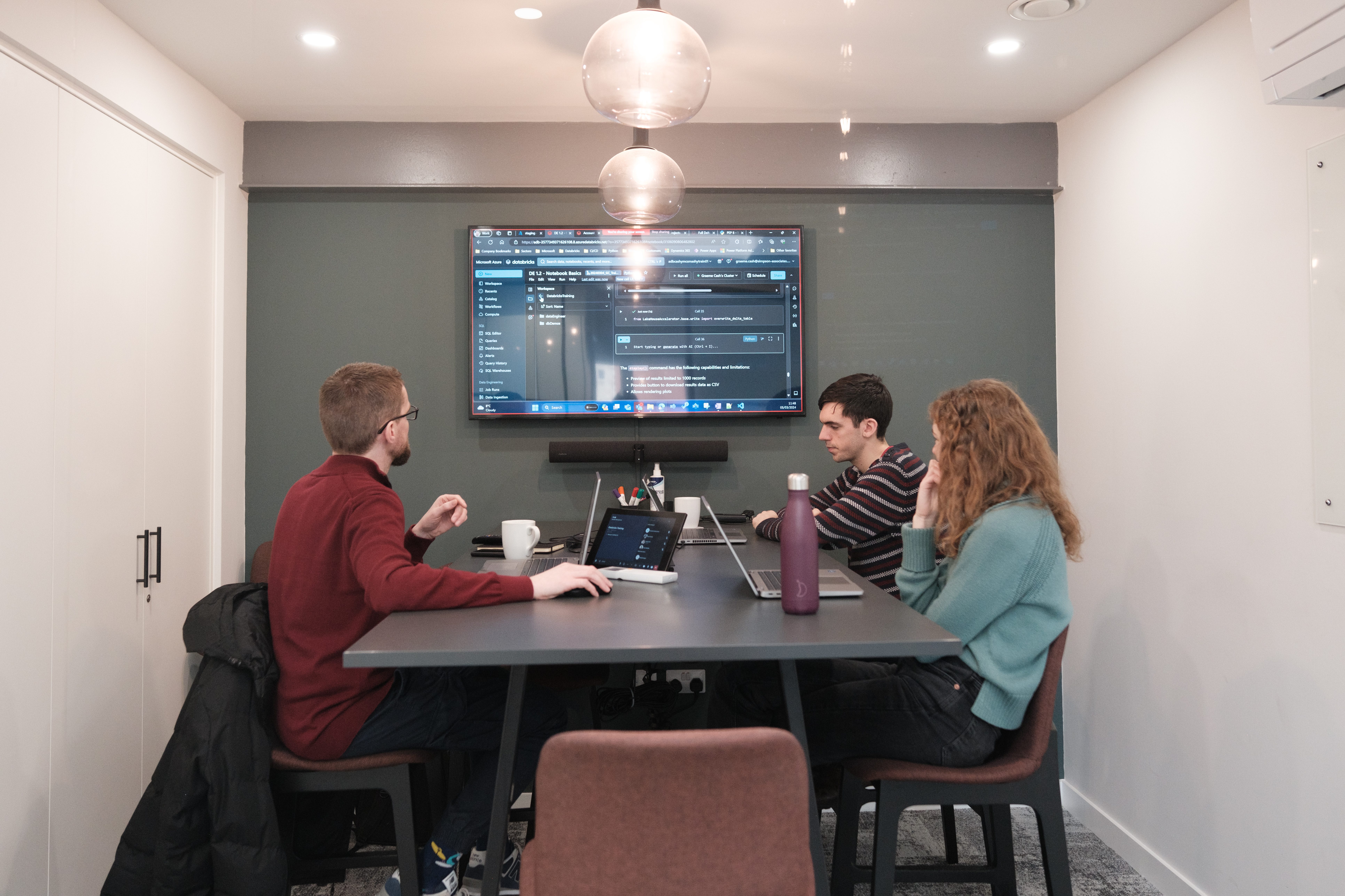 3 people sat in a meeting room doing training